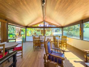 a dining room with tables and chairs and windows at Pousada Sonho de Geribá in Búzios