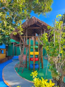 a tree house with a ladder and chairs at Pousada Sonho de Geribá in Búzios