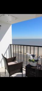 un balcón con 2 sillas y una mesa con flores en Relaxing Galveston Oceanfront Escape With Heated Pool, en Galveston