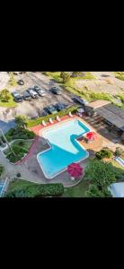 Una vista aérea de una gran piscina con sombrillas. en Relaxing Galveston Oceanfront Escape With Heated Pool, en Galveston