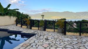 a fence with potted plants next to a pool at Residencial Azul Marinho - Suítes por temporada in Ilhabela