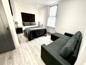 una sala de estar con un sofá y una cama en Hornby Hottub and Jacuzzi Suites, en Blackpool 64 fotos más