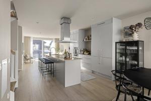 a kitchen with white cabinets and a table with chairs at Townhouse with Jacuzzi in Älta