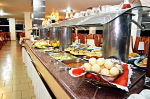 una línea de buffet con muchos platos de comida en Praia Sol Hotel en Santa Terezinha de Itaipu
