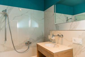 ein Badezimmer mit Waschbecken und Dusche in der Unterkunft Apartmenthaus am Dom mit Parkplatz in Zwickau