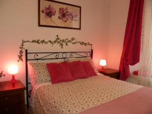 1 dormitorio con 1 cama con almohadas rojas y 2 lámparas en Holiday Home Il Sogno A San Pietro, en Roma