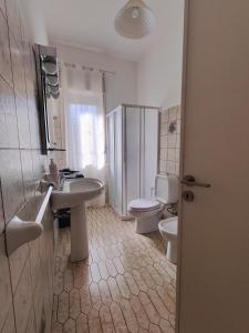 e bagno con servizi igienici, lavandino e servizi igienici. di Lemon Tree Home ad Aci Castello Altre 5 foto