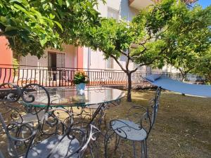 un tavolo di vetro e sedie con una tavola da surf sopra di Lemon Tree Home ad Aci Castello