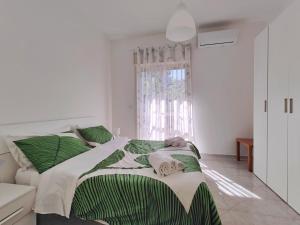 una camera da letto con un grande letto con lenzuola verdi e bianche di Lemon Tree Home ad Aci Castello