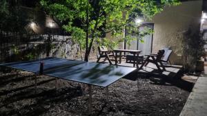 a ping pong table and chairs in a yard at בצל פקאן in Avnei Eitan
