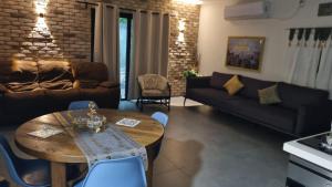 a living room with a table and a couch at בצל פקאן in Avnei Eitan
