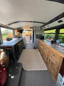 an interior of an rv with a kitchen and a table at The Bus On The Hill in Huntsham
