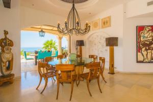 ein Esszimmer mit Tisch und Stühlen und dem Meer in der Unterkunft Villa Buena Vida by Cabo Villas in El Tule