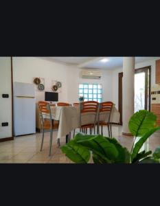 une cuisine et une salle à manger avec une table et des chaises dans l'établissement Appartamento Maria Giovanna Caletta beach, à La Caletta