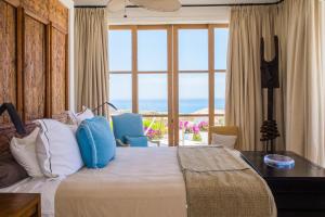 ein Schlafzimmer mit einem großen Bett mit einem großen Fenster in der Unterkunft Villa Buena Vida by Cabo Villas in El Tule