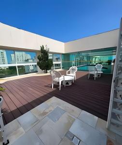 een terras met stoelen en tafels in een gebouw bij Flat ao lado do Mar Four Season in Guarujá