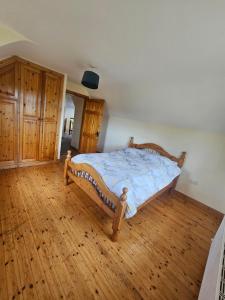 a bedroom with a bed with a wooden floor at Beacon View, Church Cross, Skibbereen, County Cork in Church Cross +3 photos