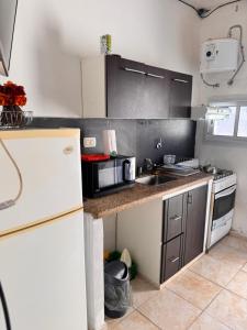 a kitchen with a white refrigerator and a sink at Departamentos Ines in Villa María +14 photos