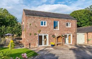 a brick house with a patio and a yard at Church House Barn Lake District & Solway Coast with Solway Firth views in Silloth