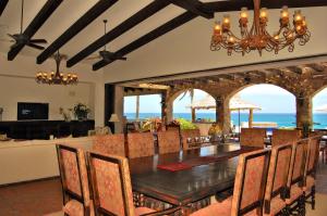 a dining room with a table and chairs and the ocean at Villa Estero by Cabo Villas in San José del Cabo