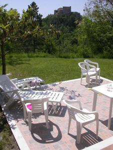 a group of white chairs and tables on a patio at Family house with garden in Fosdinovo