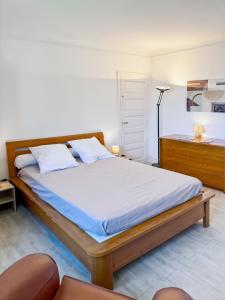 a bedroom with a bed and a desk with a lamp at La maison Hortensias Vic-Sur-Cère - 6pers in Vic-sur-Cère