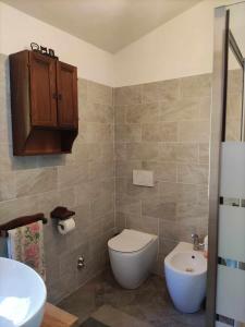 a bathroom with a white toilet and a sink at Family house with garden in Fosdinovo +39 photos