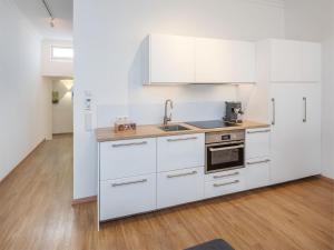 een keuken met witte kasten en een spoelbak bij Moderne stilvolle Wohnung im Herzen Münchens in München +16 foto's
