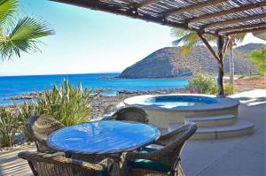 a patio with a table and chairs and the ocean at Villa Langosta by Cabo Villas in La Paz +15 photos