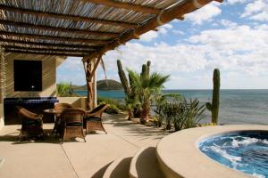 a patio with a table and chairs and a swimming pool at Villa Langosta by Cabo Villas in La Paz