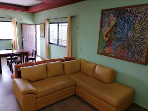 a living room with a couch and a painting on the wall at Amplios y cómodos apartamentos en Playa del Carmen in Playa del Carmen