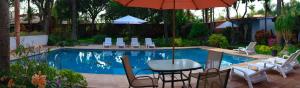 a table and chairs with an umbrella next to a pool at Villas Don Zeferino in Chiconcuac