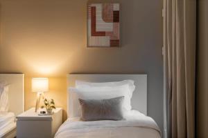 een slaapkamer met een bed met een kussen en een lamp bij 3BR Luxury Stay in Riyad