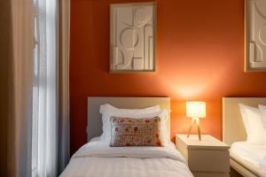 een slaapkamer met oranje muren en een bed met een kussen bij 3BR Luxury Stay in Riyad