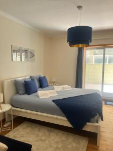a bedroom with a large bed with blue pillows at Sea and Nature Escape in Furadouro