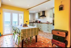 a kitchen with yellow walls and a table with chairs at Charming Coastal Retreat in Alboraya