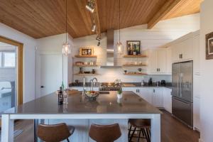 eine Küche mit einer großen Kücheninsel mit Stühlen in der Unterkunft Chalet Trappeur Luxury Cottage Retreat with Hot Tub in Mont-Tremblant