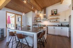 eine Küche mit einer großen Insel mit Barhockern in der Unterkunft Chalet Trappeur Luxury Cottage Retreat with Hot Tub in Mont-Tremblant + 16 Fotos
