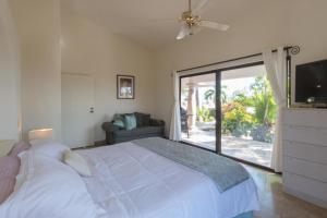 una camera da letto con un letto bianco e una porta scorrevole in vetro di Villa Sun Guadalupe by Cabo Villas a San José del Cabo Altre 22 foto