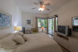 una camera con letto, ventilatore a soffitto e TV di Villa Sun Guadalupe by Cabo Villas a San José del Cabo