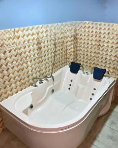 a white bath tub with two chairs in it at Visita Lima con excelente ubicación, wifi gratis y vistas en "Hostal Paris" in Lima