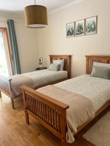 a bedroom with two beds and a bench and a window at Sea and Nature Escape in Furadouro