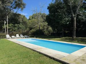 a swimming pool in a yard with chairs and trees at Apart Boutique Macedonia in San Lorenzo