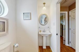 une salle de bain blanche avec un lavabo et un miroir dans l'établissement A Wave From It All, à Dauphin Island 26 autres photos