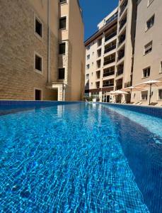 a swimming pool with blue water in a building at Lux Apartment 14 in Kravlja