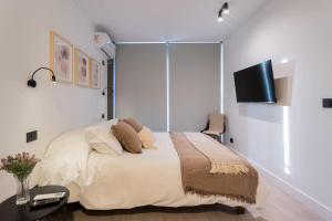 a bedroom with a bed and a flat screen tv at Las Condes Hideaway Modern 2BR 5 Guests in Santiago