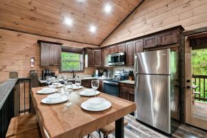 a kitchen with a table and a stainless steel refrigerator at The Wacky Woodpecker in Pigeon Forge
