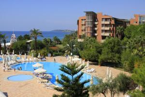 a swimming pool with chairs and umbrellas in a resort at AQI Pegasos Club in Avsallar