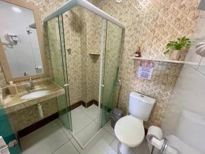 a bathroom with a shower and a toilet and a sink at Flats Corais in Maragogi