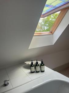 two bottles sitting on a bathroom sink in front of a window at The Neuk Achmore Plockton in Stromeferry +35 photos